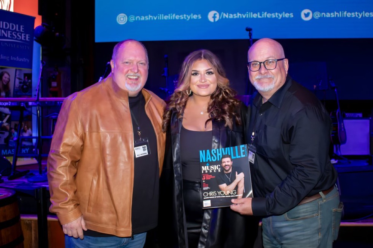 Odie with a young artist holding a Nashville Lifestyles magazine at an MTSU event